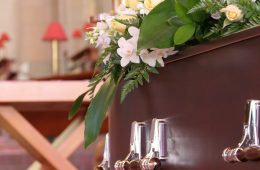closeup shot of a funeral casket in a hearse or chapel or burial at cemetery