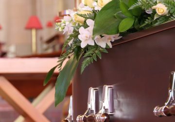 closeup shot of a funeral casket in a hearse or chapel or burial at cemetery