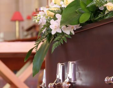 closeup shot of a funeral casket in a hearse or chapel or burial at cemetery