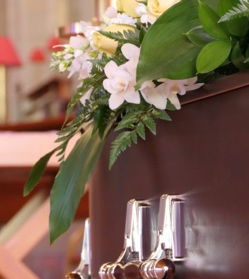 closeup shot of a funeral casket in a hearse or chapel or burial at cemetery