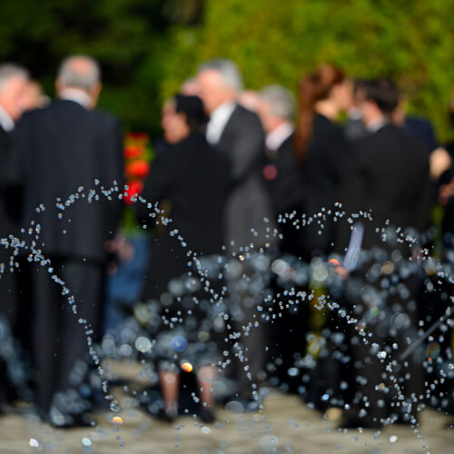 Blurred people in black suits on funeral