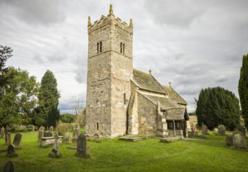 Church exterior, Holy Trinity Norman church in Little Ouseburn, Yorkshire, UK